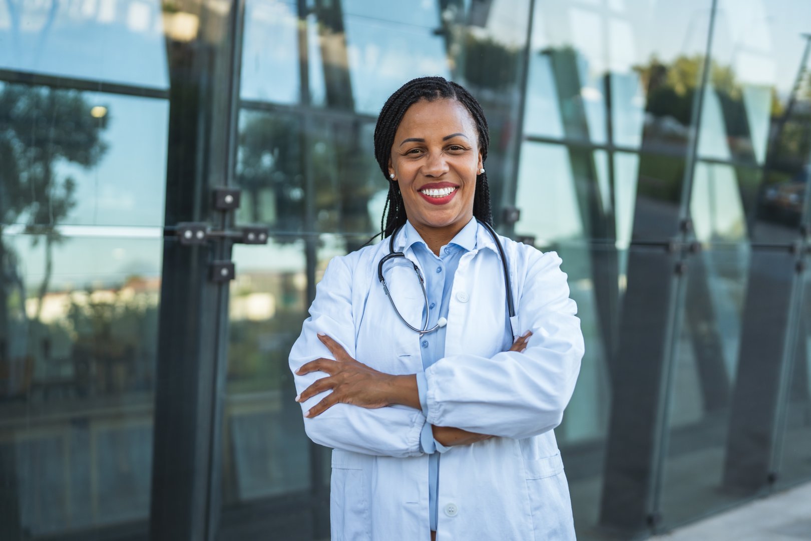 Portrait of african american mature woman doctor stand in front modern hospital