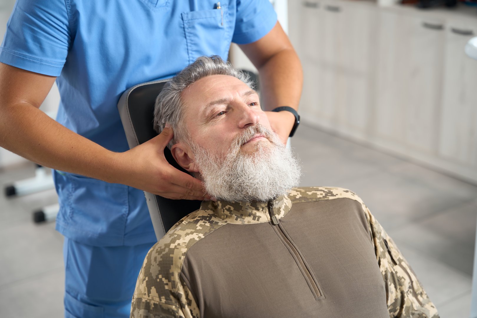 Male chiropractor works with a patient in a rehabilitation center, he gives him a massage