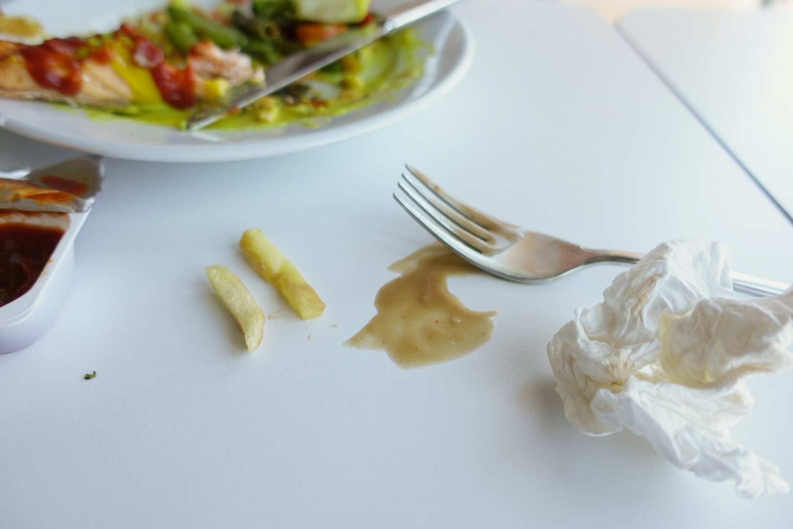 Closeup of spilled sauce artistically splattered on a plate and bowl, showcasing dining chaos