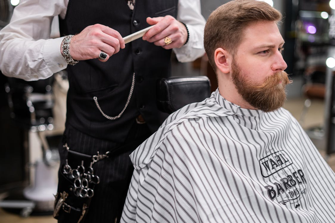 Professional barber giving client a precision haircut in barbershop