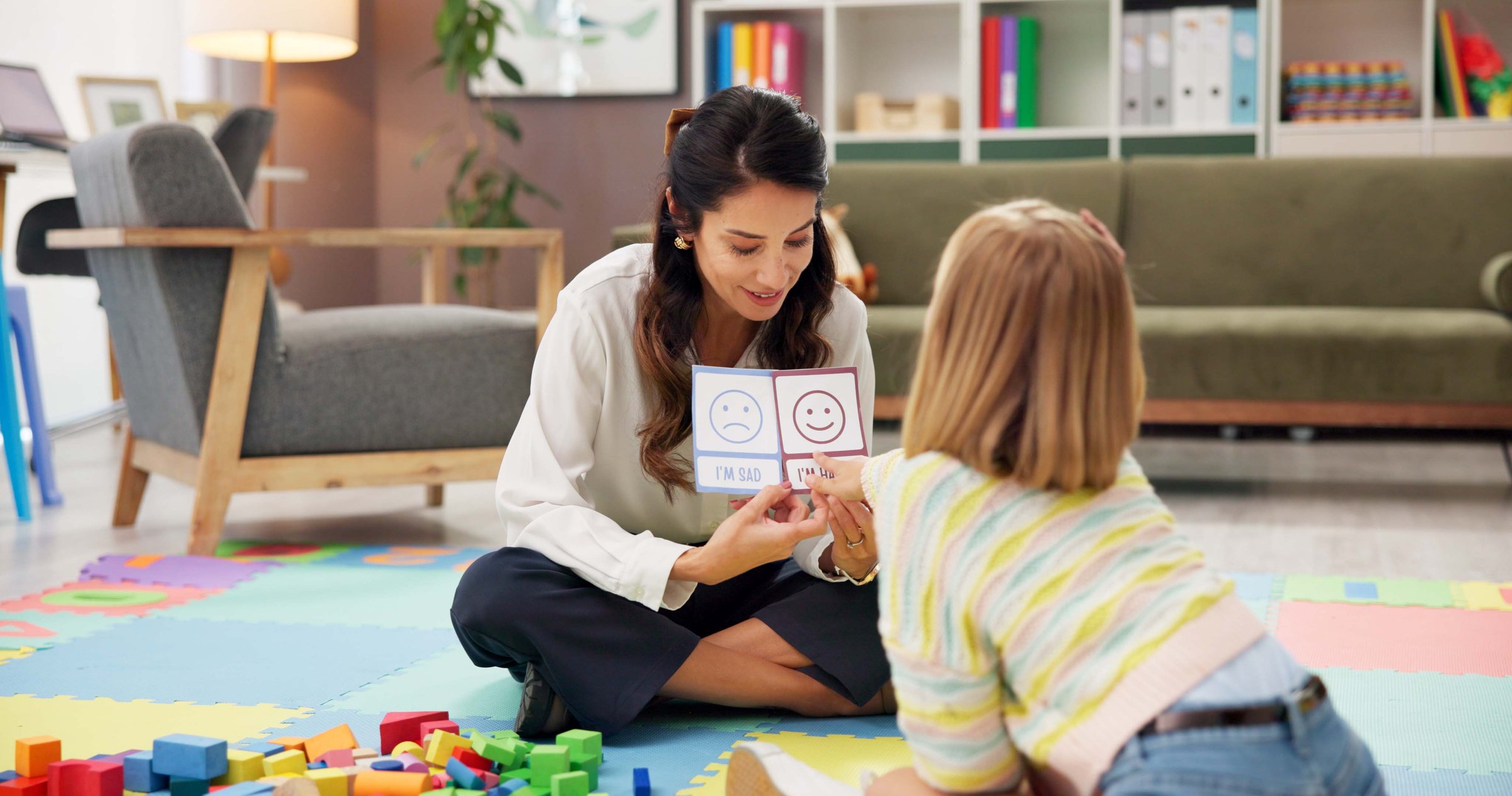 Woman, teacher and child in classroom with visual lesson for private tutoring or assessment at elementary school. Female person, educator or academic therapist with pictures for childhood development