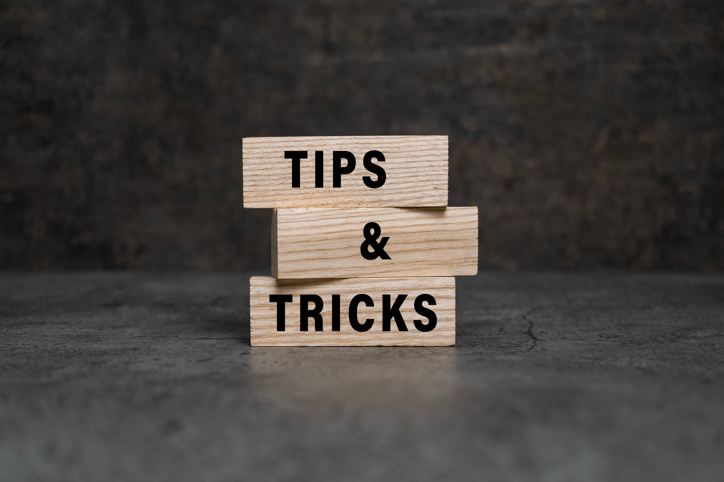 tips and tricks words on wooden blocks isolated on dark background