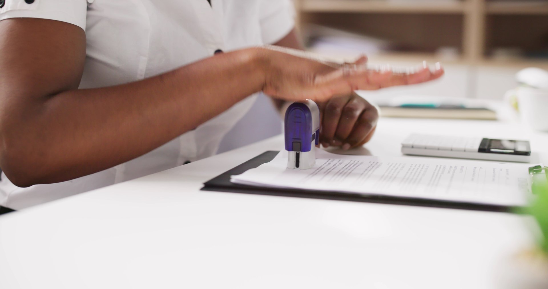 Public Notary Putting Company Stamp On Contract At Office Desk