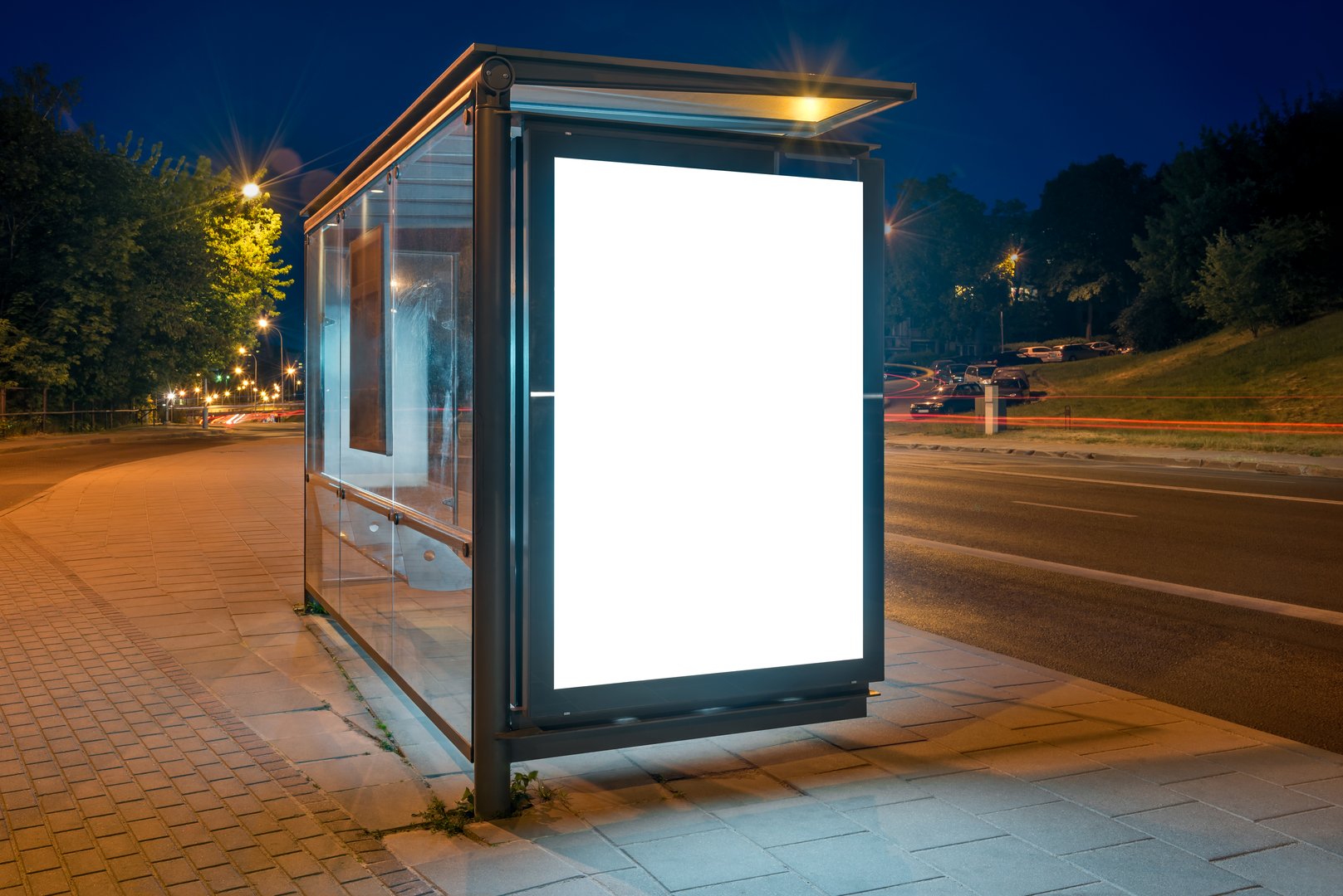Mockup Of Bus Stop Advertising Billboard On A City Street At Night. Outdoor Poster Lightbox With Car Light Trails In The Background
