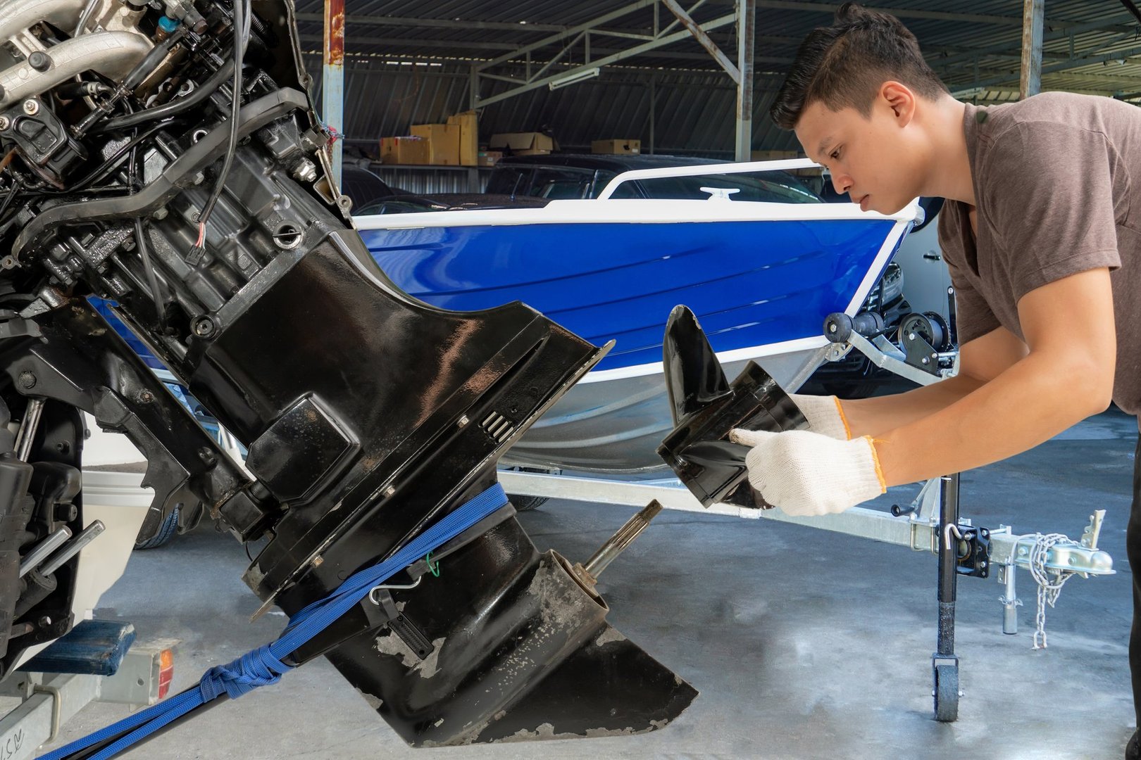 Repairing engines on aluminum boats, The technician is removing the boat parts to make the paint