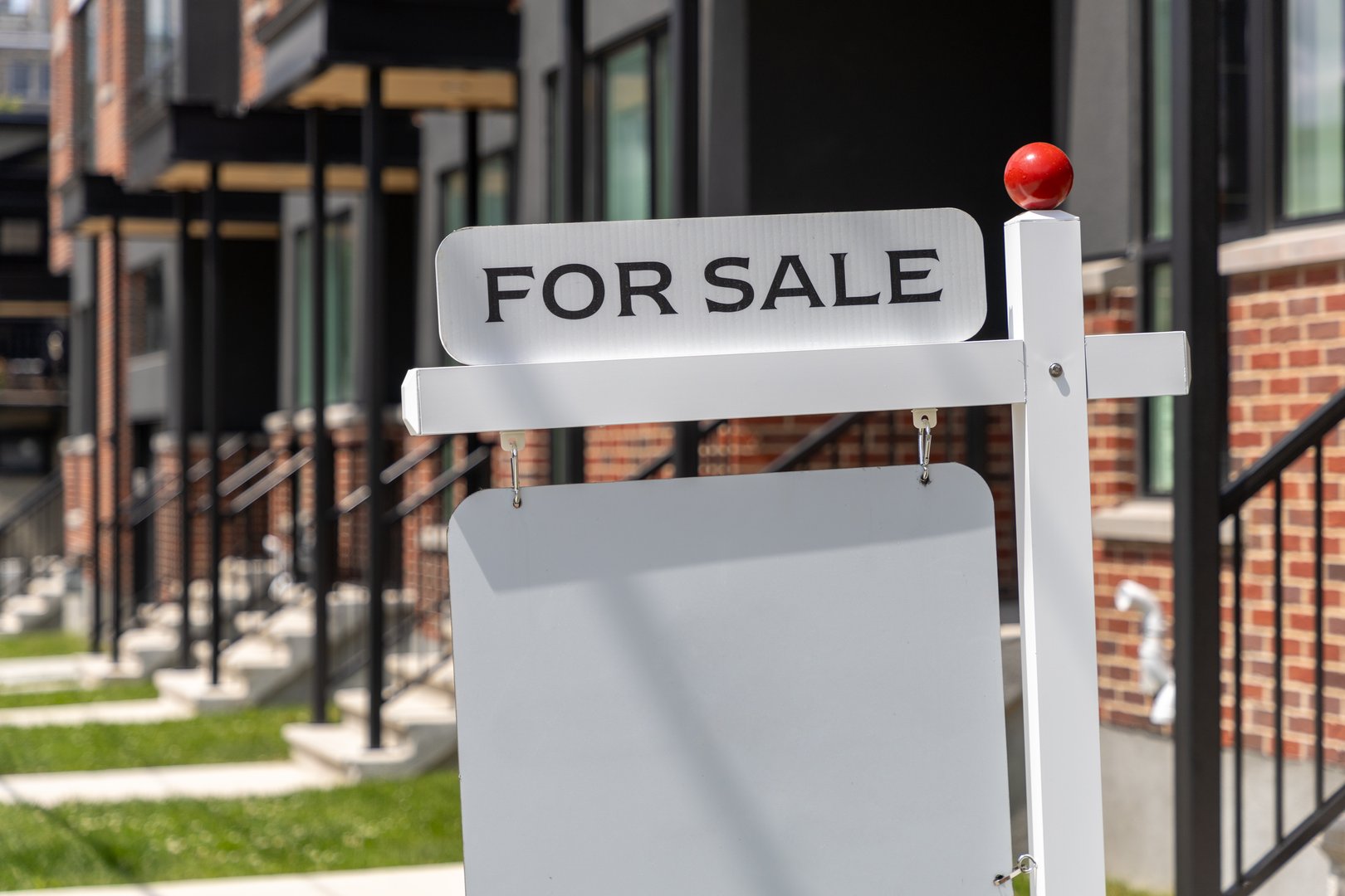 For sale sign outside a residential house, real estate market concept