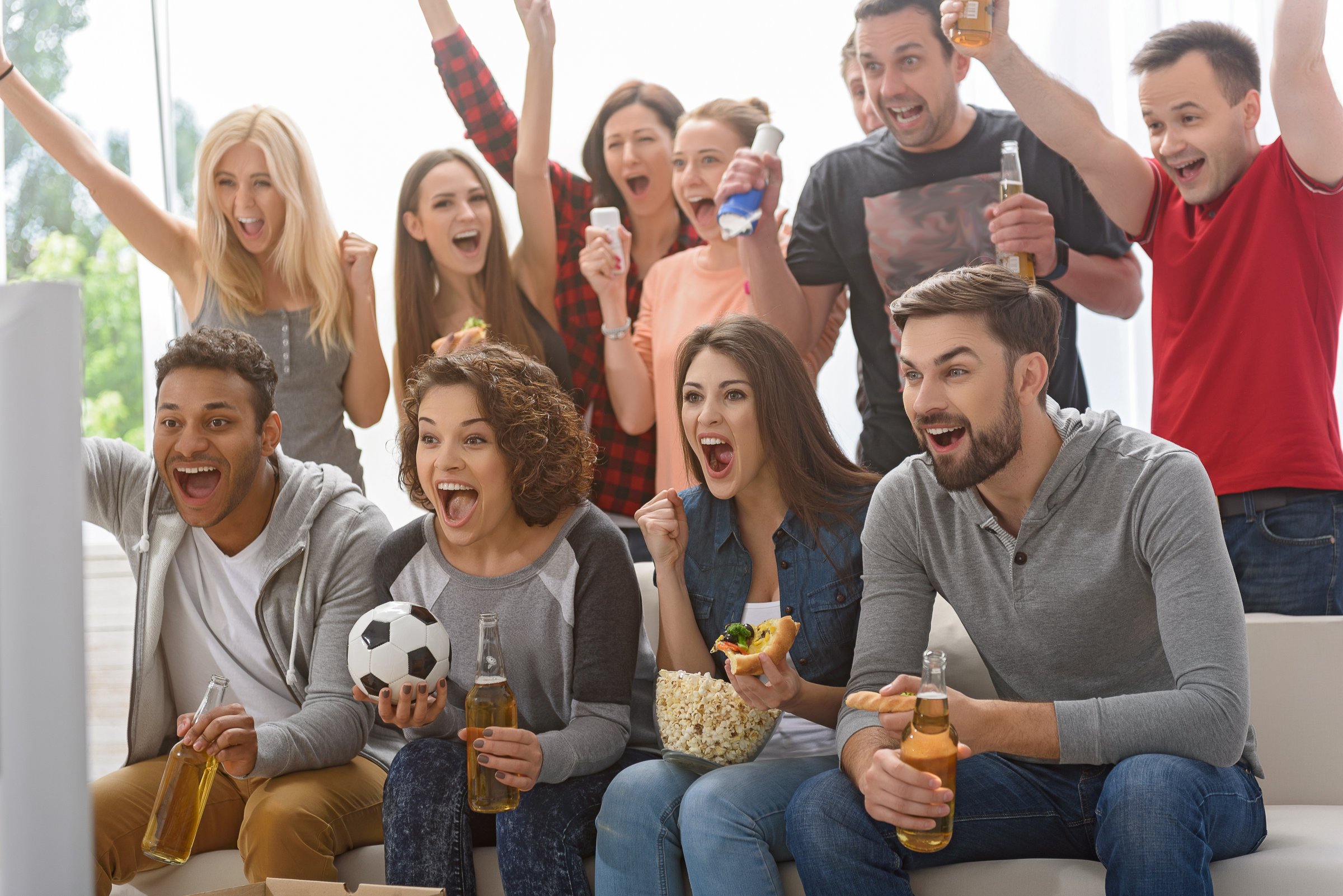 Finally we have got first goal. Group of happy friends rooting for their soccer team on TV and celebrating goal