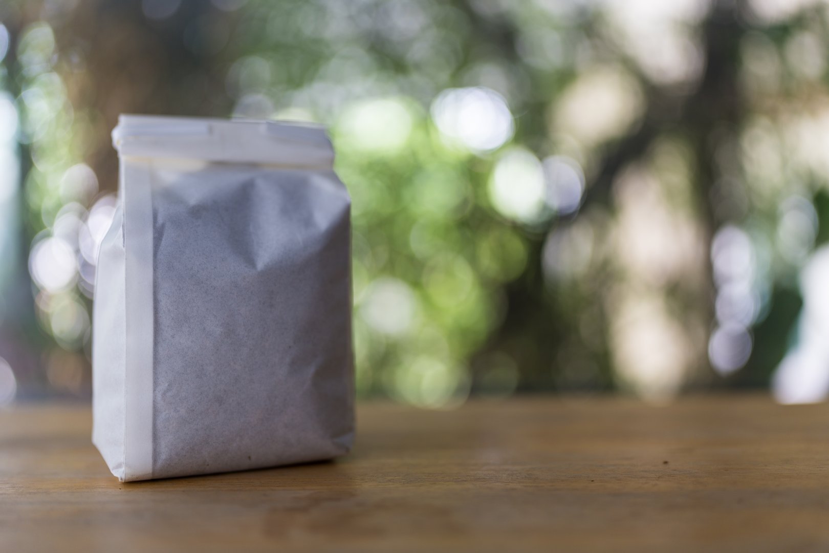 Coffee powder in white packaging on wood table