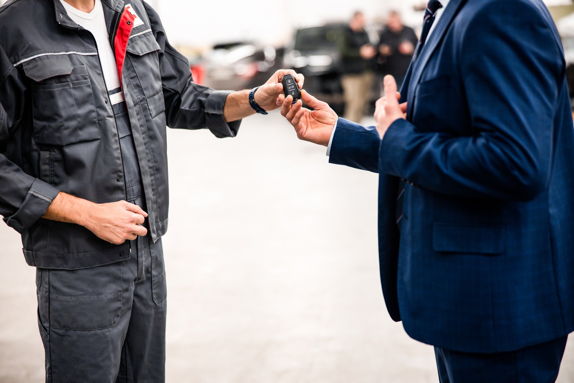 Mechanic taking a car key fob from his clients hand