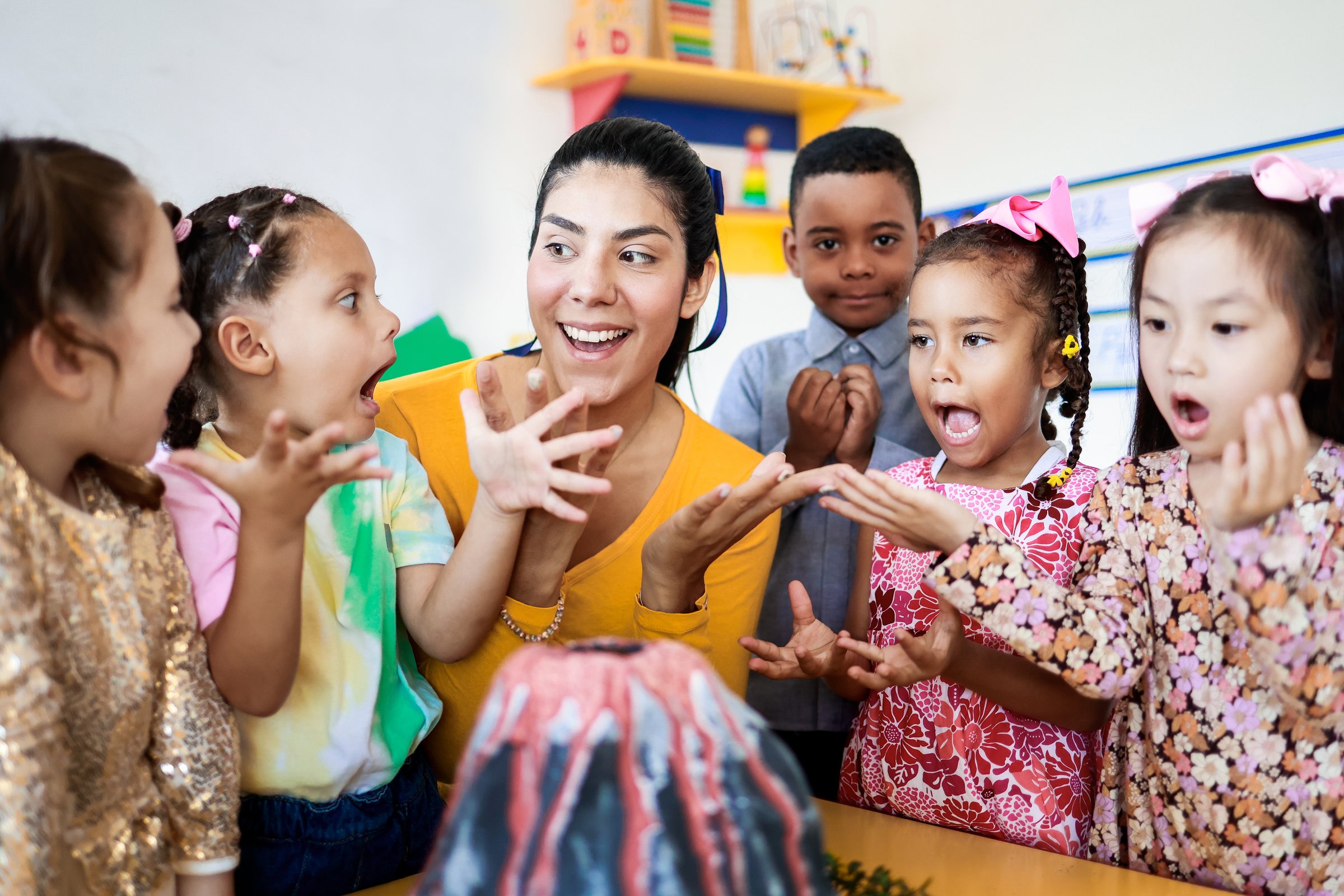 Teacher and group of children learning about volcanos at science kindergarten project