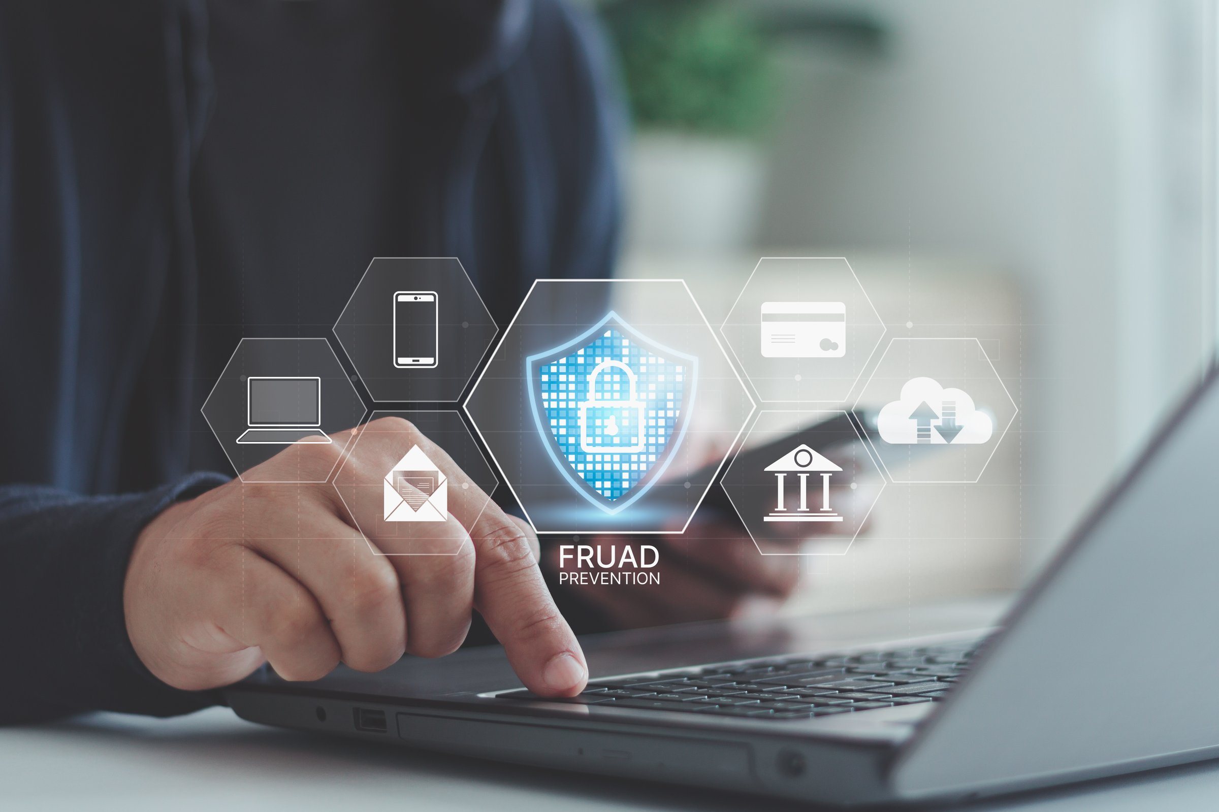 Businessman hand using laptop with digital shield lock icon and fraud prevention text, concept of cybersecurity, online banking protection, financial security, data privacy and anti scam technology.