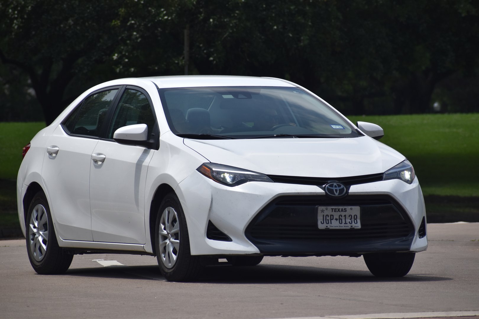Houston, TX USA April 29, 2024 - A white Toyota Corolla cruising near Herman Park in Houston