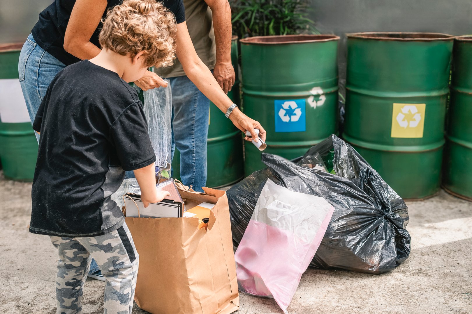 Family members are sorting their household waste, placing paper and plastic items into designated recycling bins, promoting environmental responsibility and waste reduction. Concept of climate change and social awareness.
