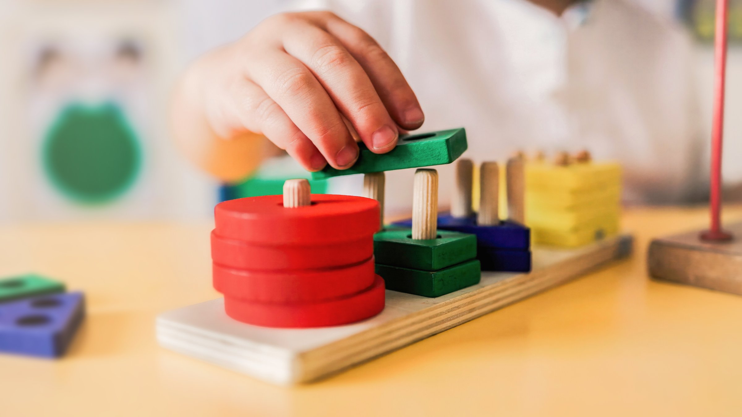 Kid playing with wood toys at pre school classroom. Kindergarten education smart games for children