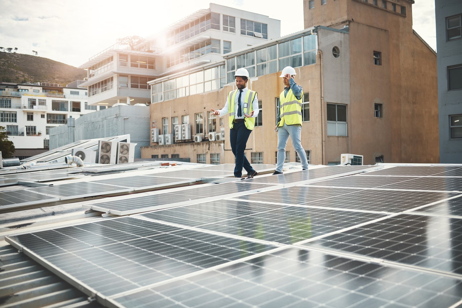 Renewable energy, solar panels and people meeting for construction, inspection and photovoltaic industry. Sustainability, engineering and electrician team planning, talking and working on electricity