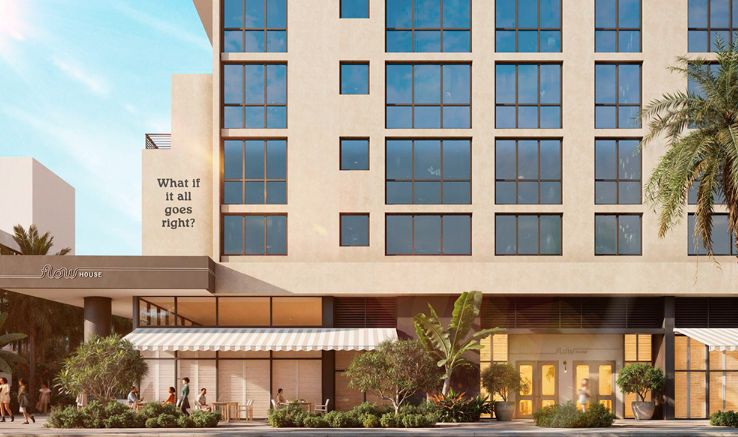 Modern building with large windows, street-level shops, and a sign reading "What if it all goes right?" on the facade.