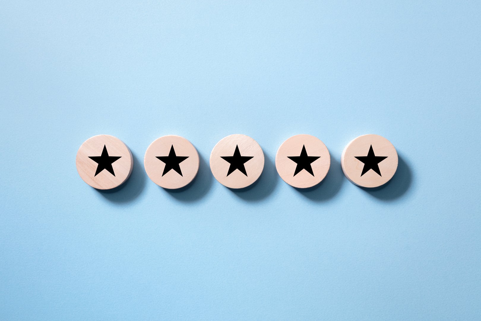 Customer experience feedback rate satisfaction experience five star rating placing wooden discs on blue background