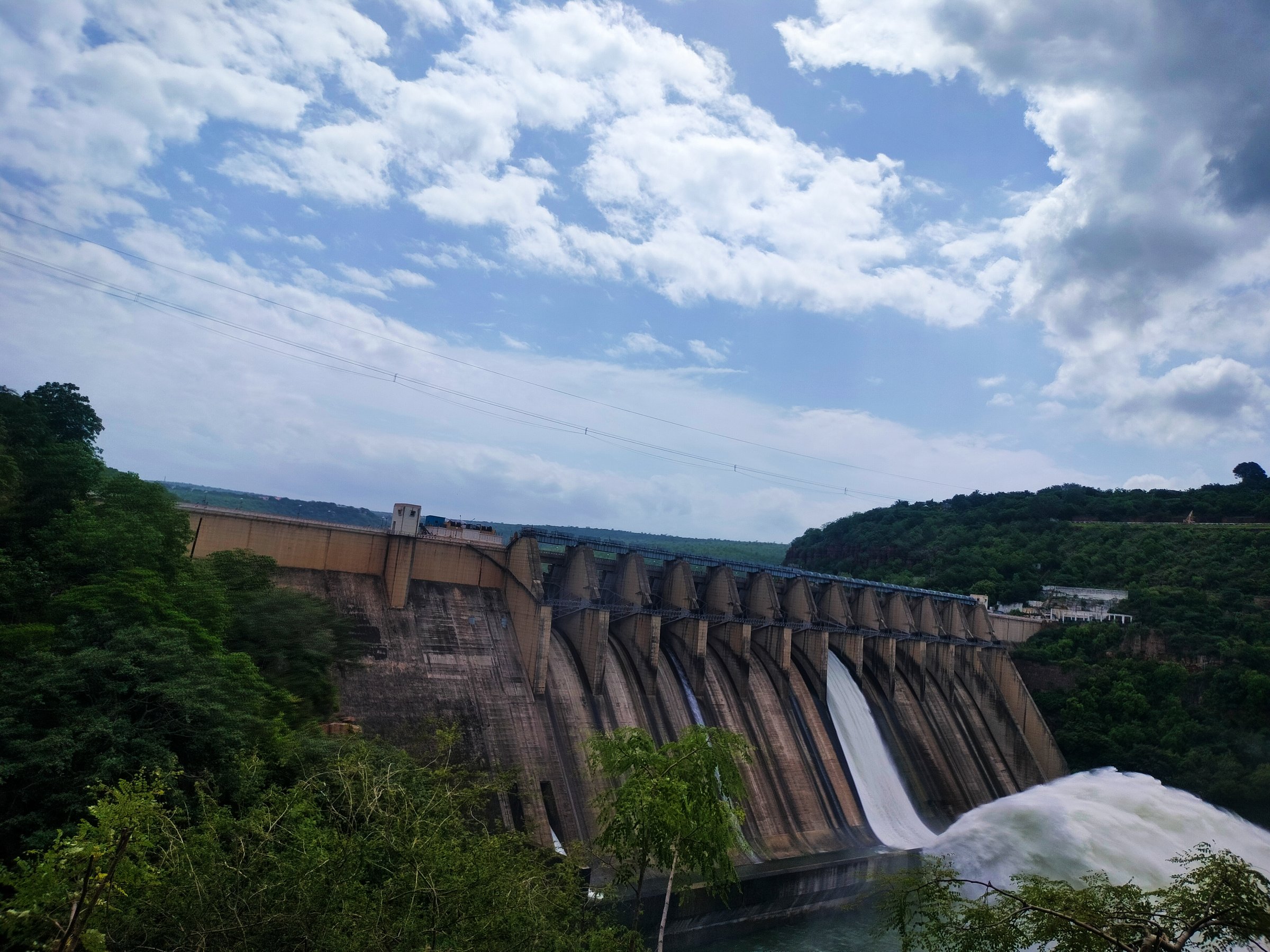 The image shows the Srisailam Dam with its gates open, releasing water. This event is significant as it marks the release of floodwaters, especially during the monsoon season when the dam nears full capacity due to strong inflows.