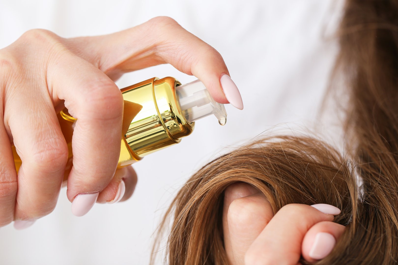 Natural hair treatment. Oil bottle in use. Beauty routine concept. Nourishment close-up view.