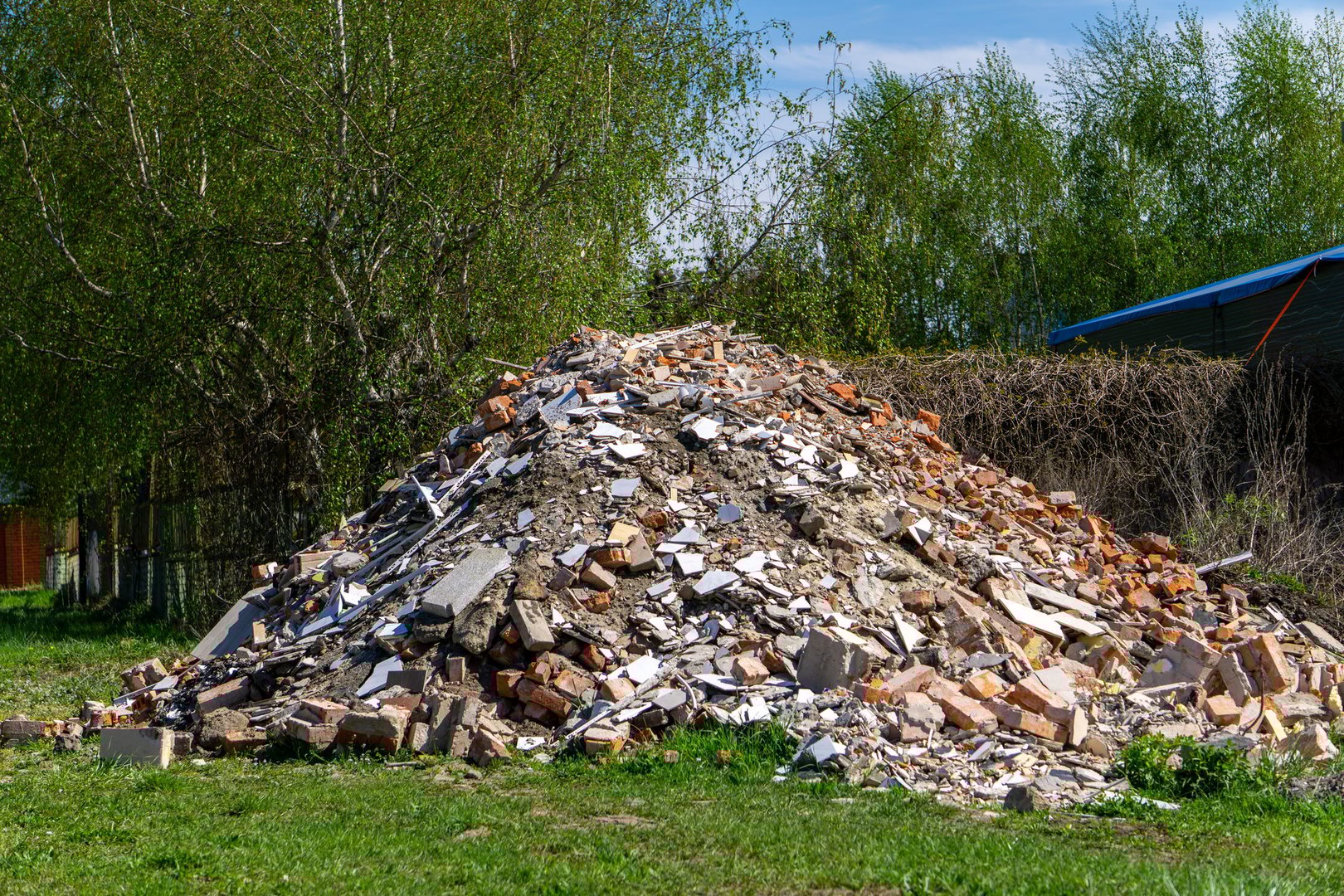 pile of construction rubble against a green background - bricks, concrete and other waste after the demolition of a building