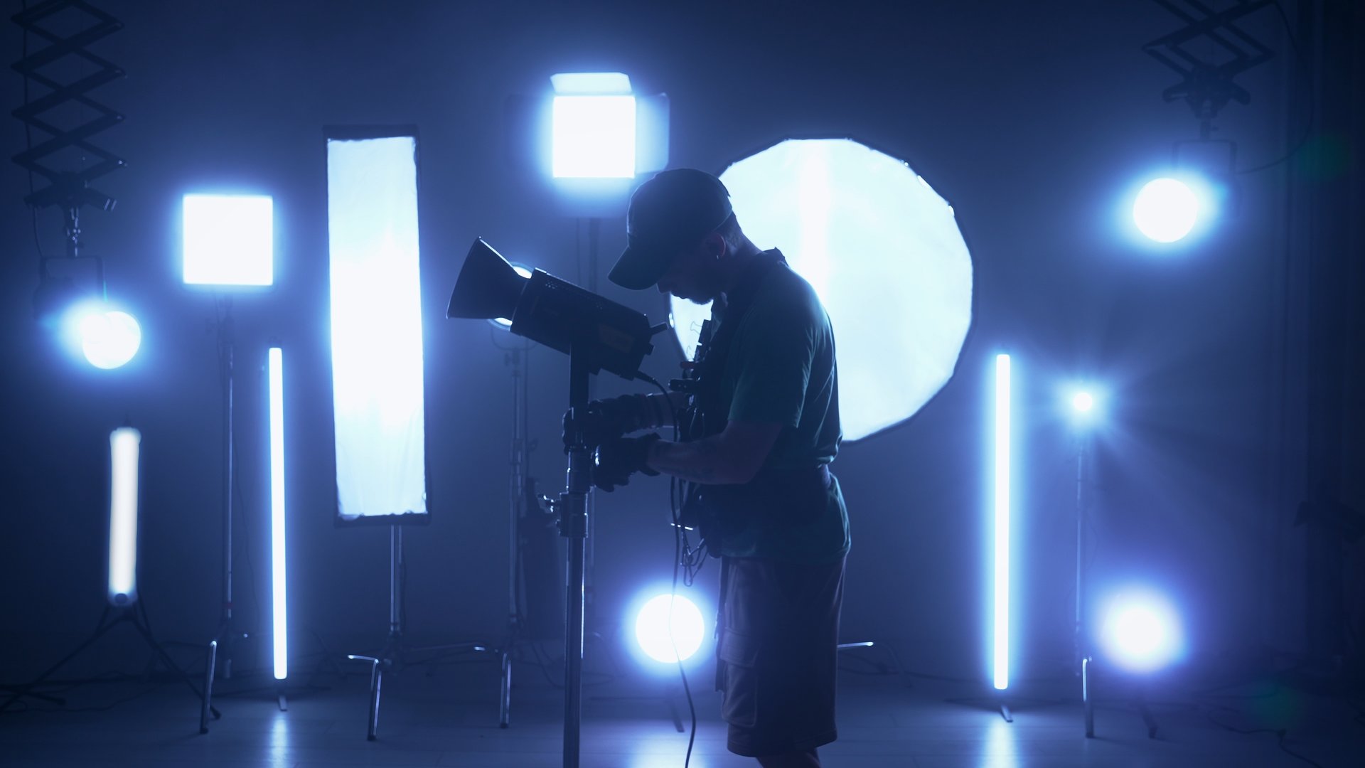 Professional filming pavilion with lighting equipment. The process of preparation for shooting a music video. Operator adjusts the equipment behind the backstage.