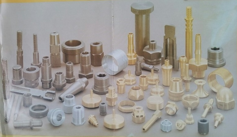 Assorted brass fittings including nuts, bolts, and connectors displayed on a surface.