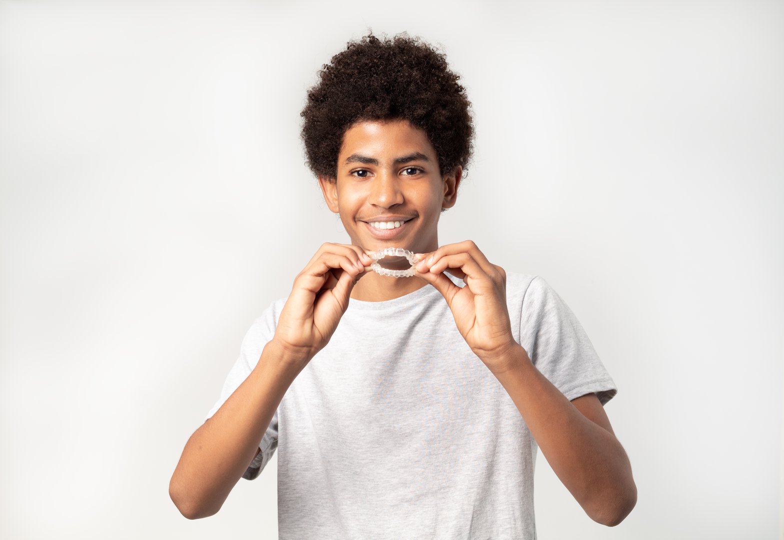 boy teenager afro with dental aligners isolated