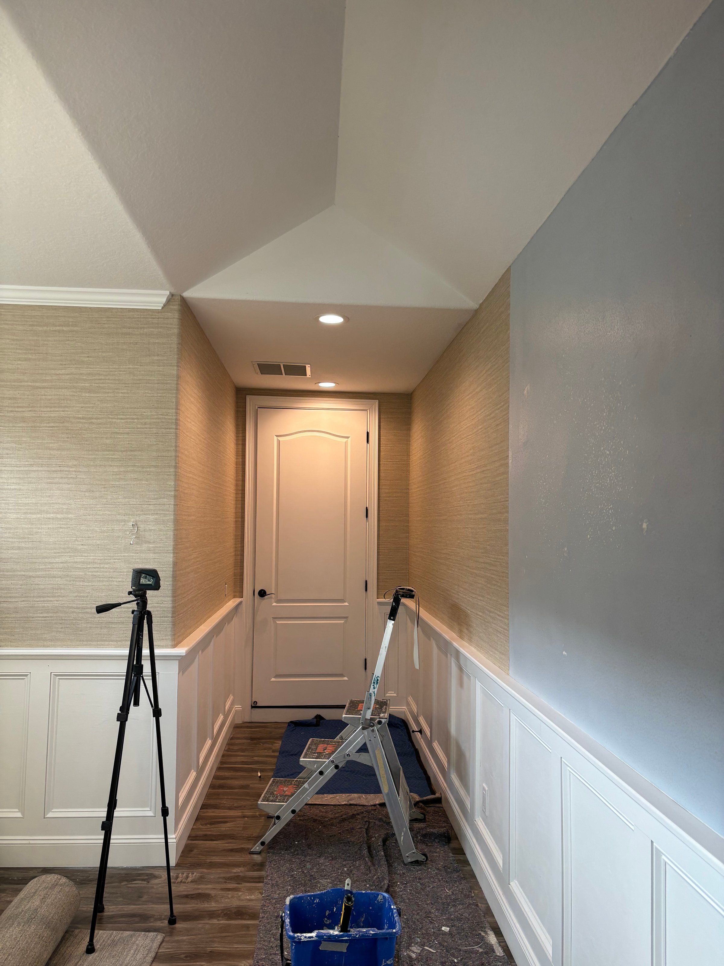 Worker attaching wallpaper. Man is putting up wallpapers on the wall. Home renovation concept