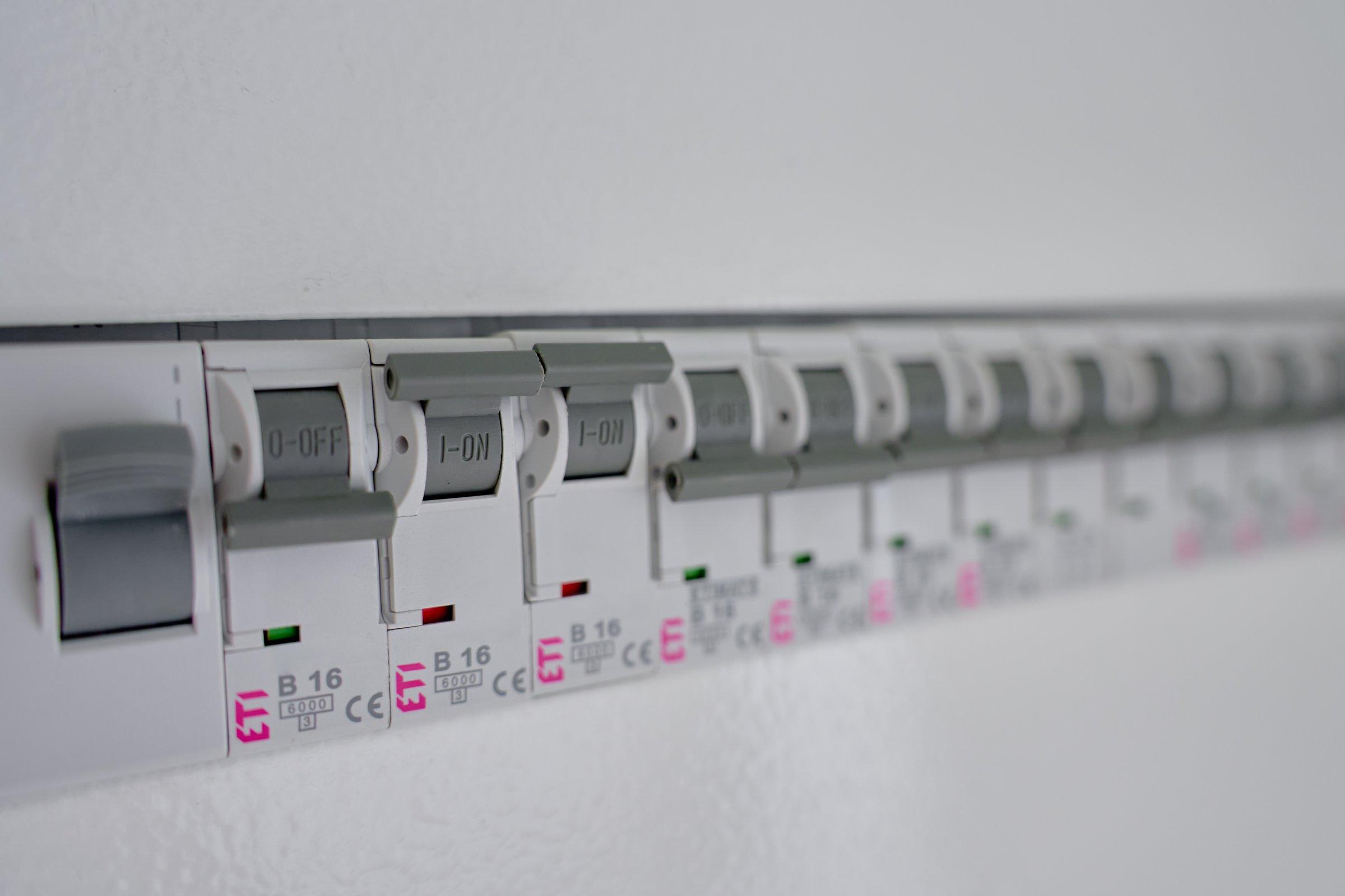 Power distribution board with row of circuit breakers and switches. Electrical panel with fuse box. Concept of home electricity safety, power distribution and electrical maintenance