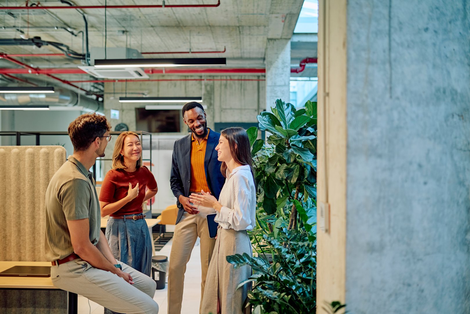 Multicultural businesspeople talking and smiling during a meeting in a modern office