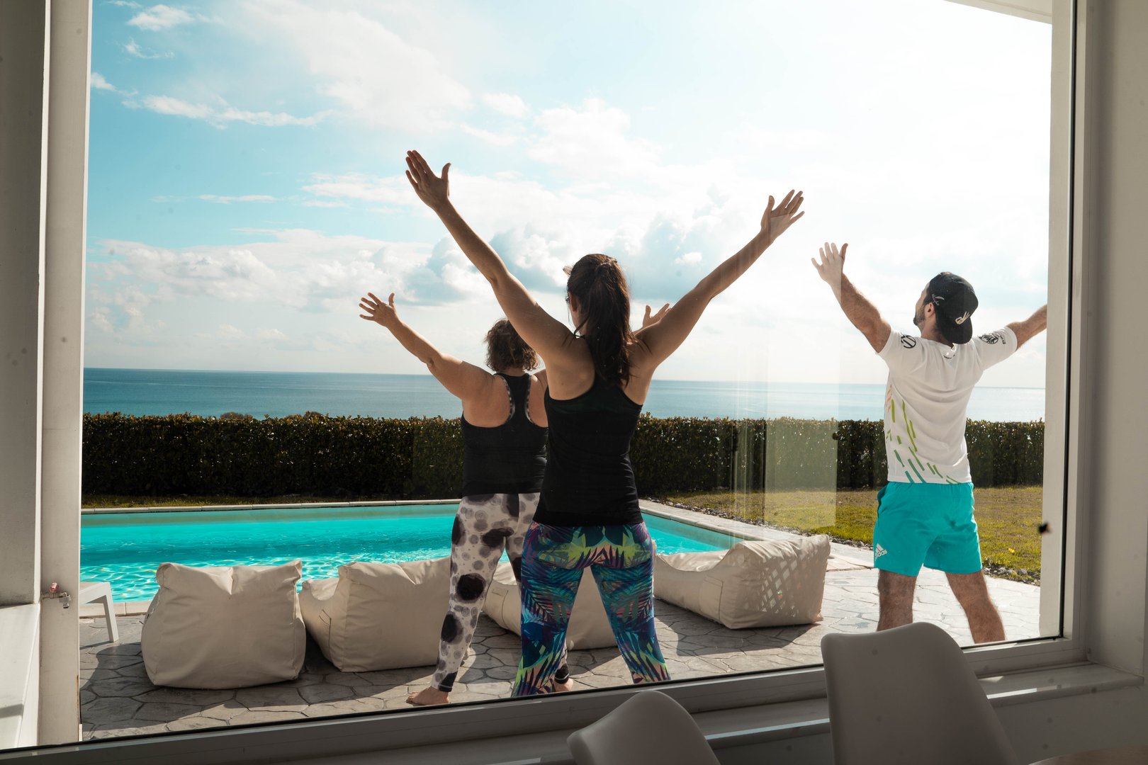 Clients performing Warrior II Pose on exercise mat in health club