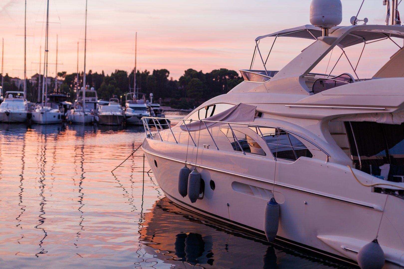 luxurious yacht moored at sunset in a serene marina surrounded by sailboats