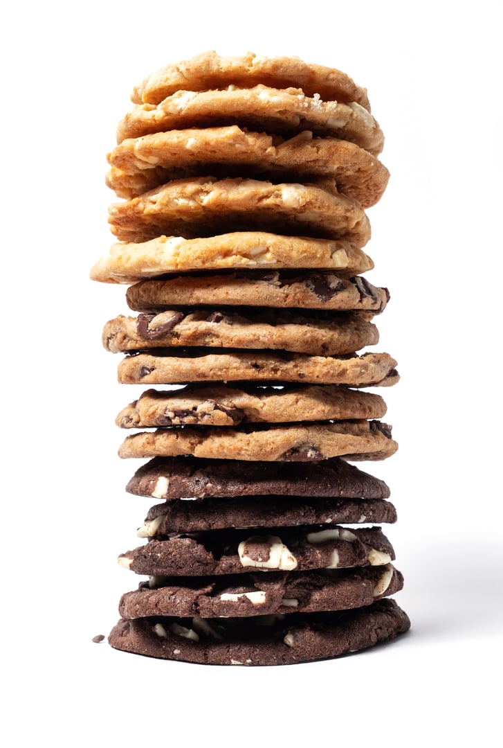 Delicious and chunky chocolate chip cookies stacked up on white background
