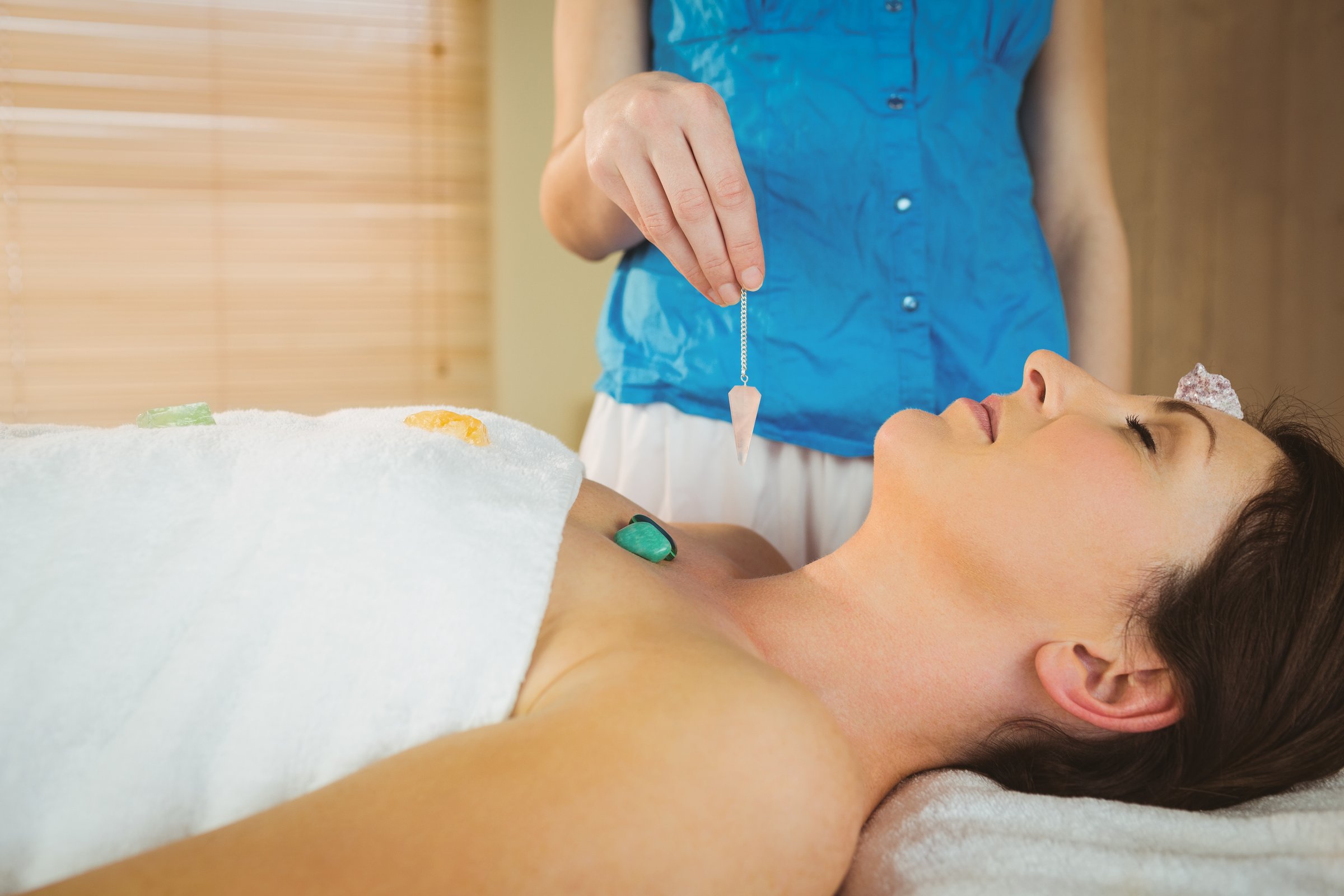 Young woman at crystal healing session in therapy room