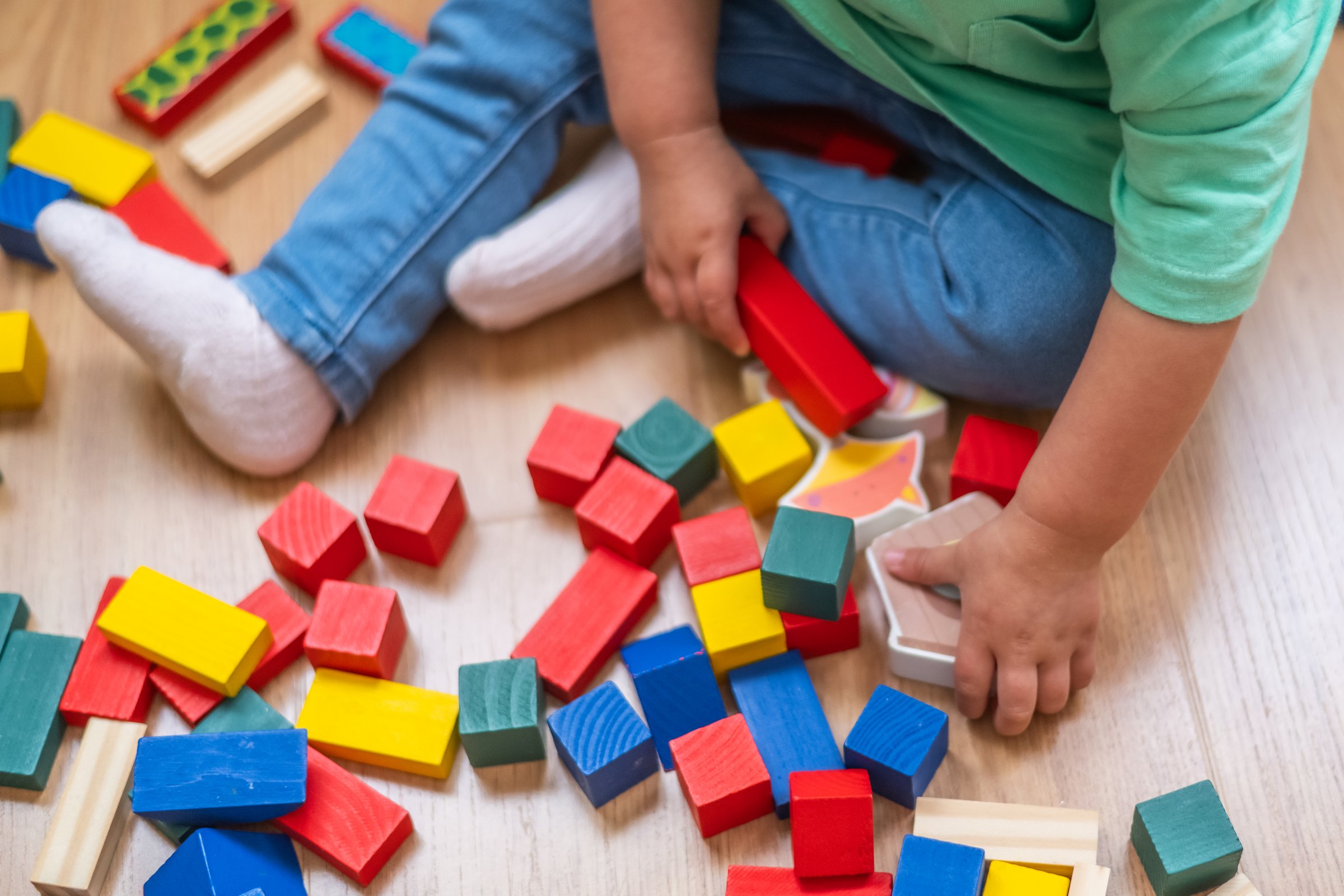 Baby Focused On Playing With Educational Building Blocks, Puzzles, And Colorful Learning Toys, Boosting Development.Baby’s Hands Playing With Colorful Educational Toys.