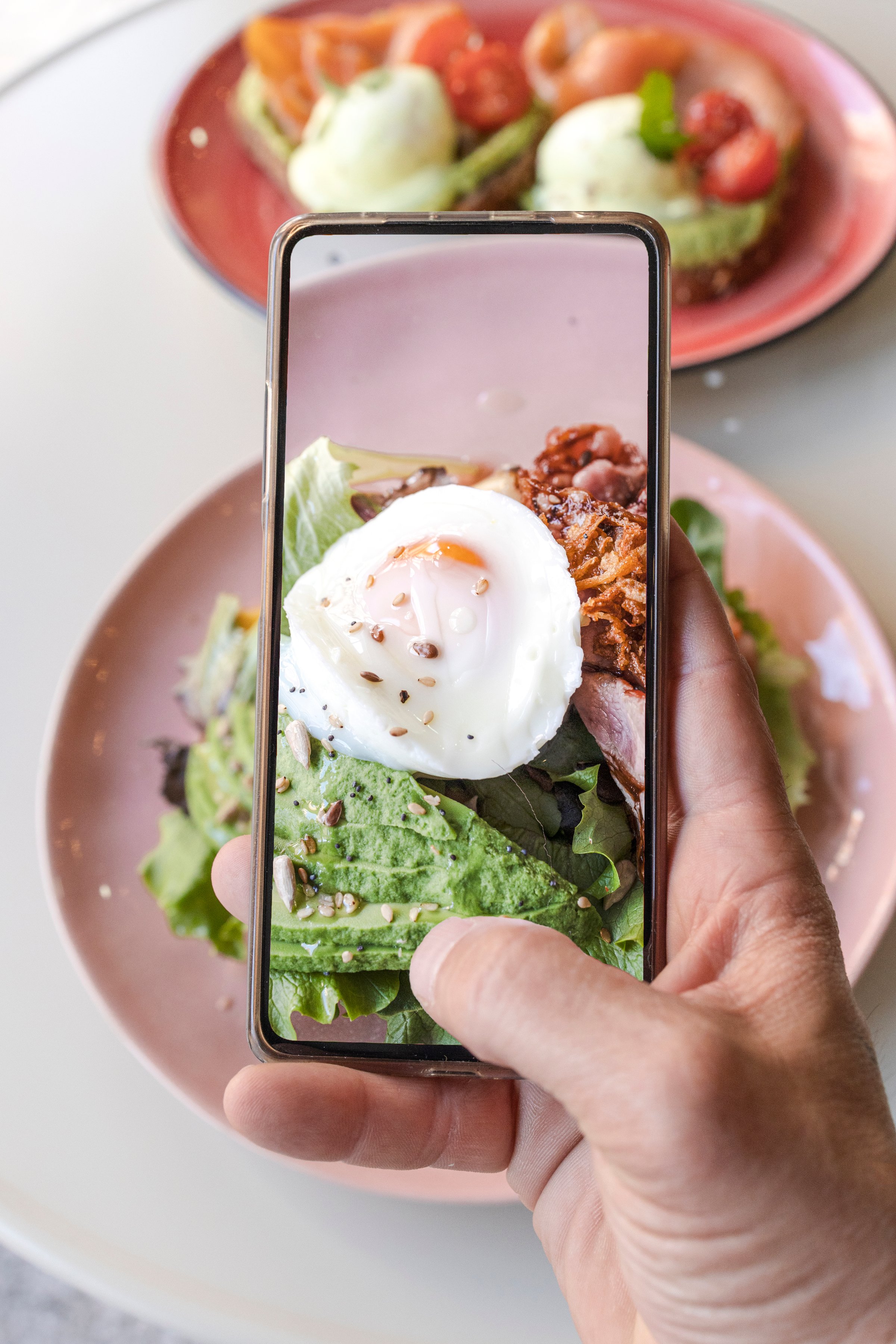 Smartphone food photography of a vegetarian lunch or dinner. Man's hands taking phone photos of food in a modern style for social networks or blogs.