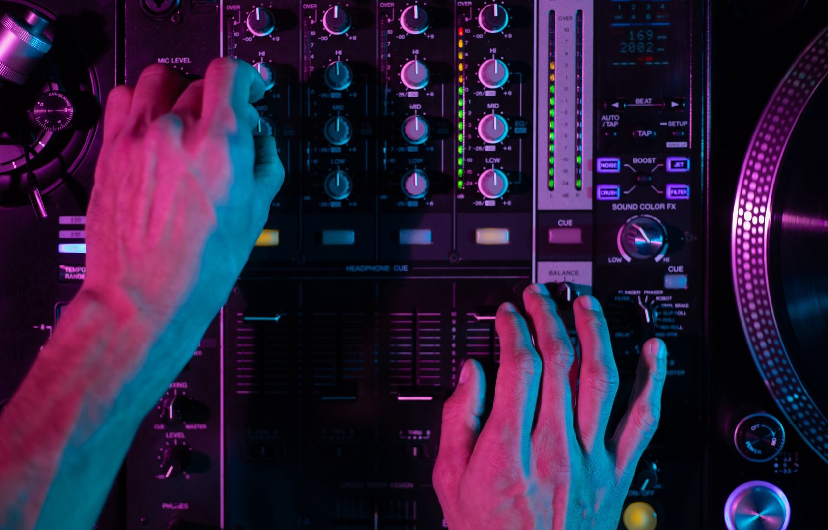 Disc jockey mixes set with professional four channel sound mixer device and vinyl turntables, shot in high resolution directly from above