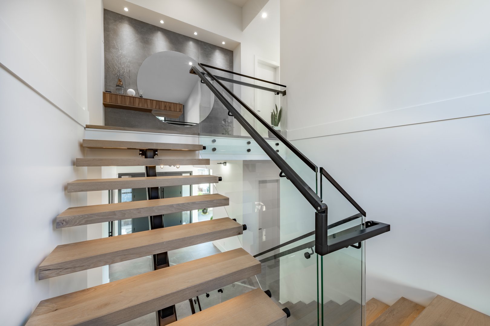 A very large modern contemporary private residence residential home spacious interiors living room, kitchen, office, recreation room, foyer, hallway, floating staircase window wall open to a patio with BBQ and swimming pool. New construction family home