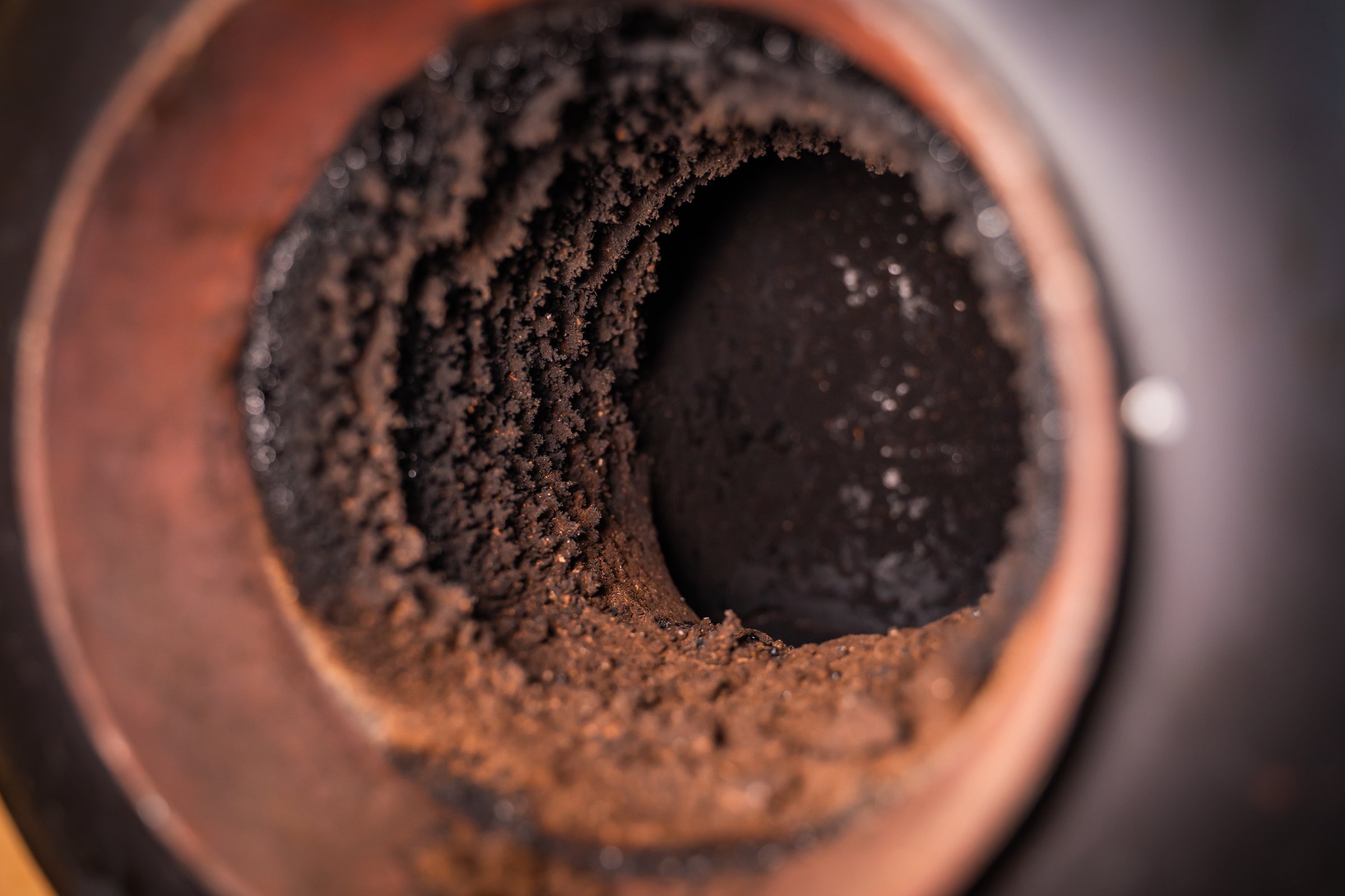 Pipe in the wall for connecting a fireplace. Chimney pipe in the wall, close-up. Soot on the inside of the pipe, maintenance and cleaning.