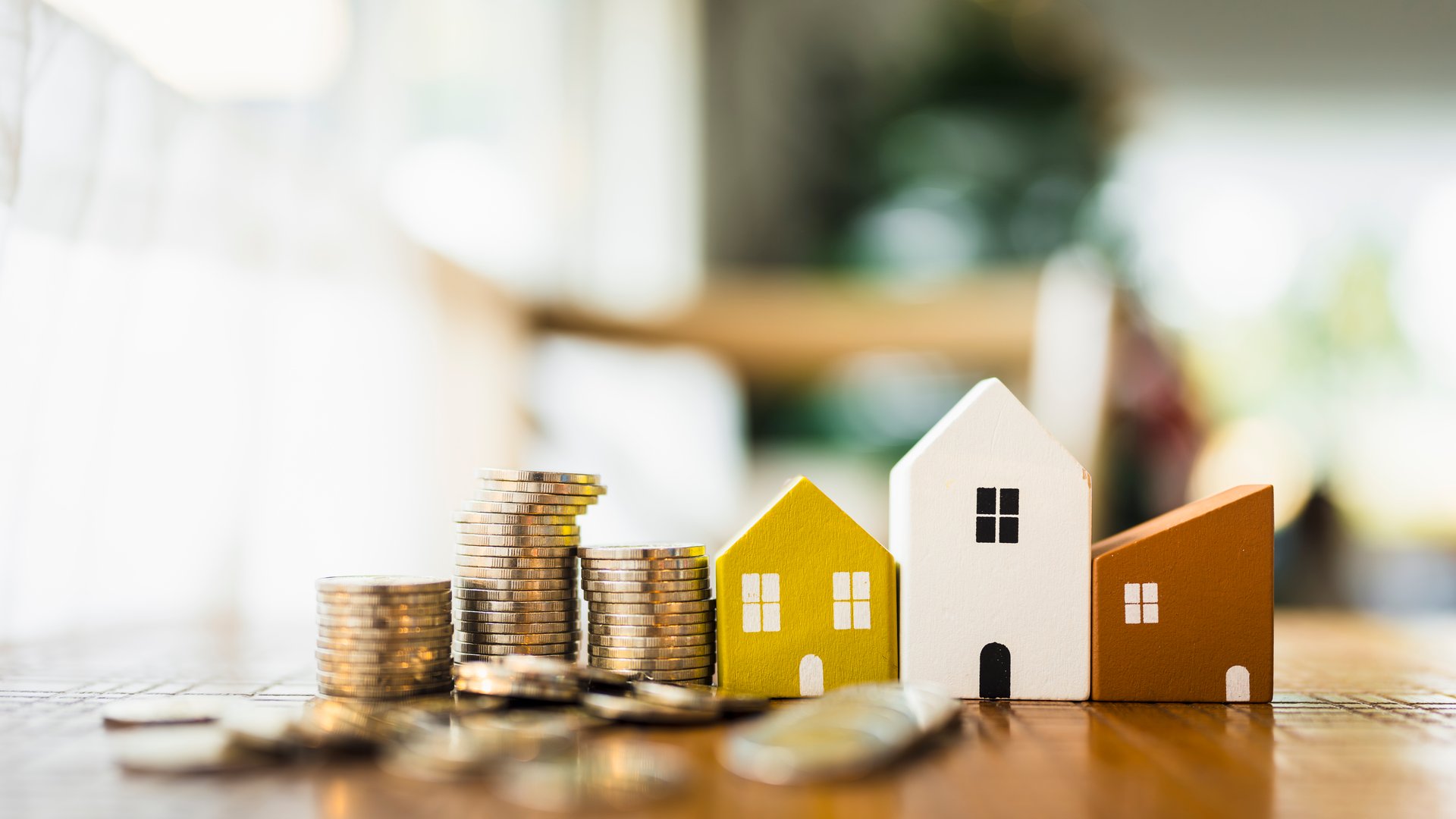 Wood house model and row of coin money with a light bulb . Money management, financial plan, business idea and Creative ideas for saving money concept.