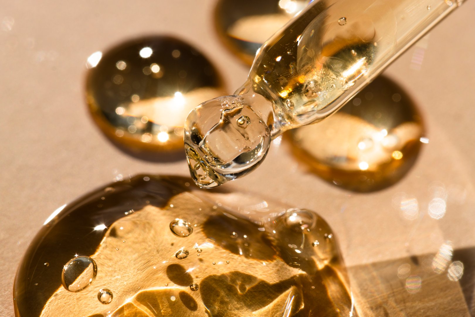 Massage and spa oil in a pipette, close-up front view beige background