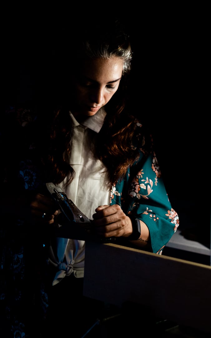 A back view of a violin maker working in a workshop