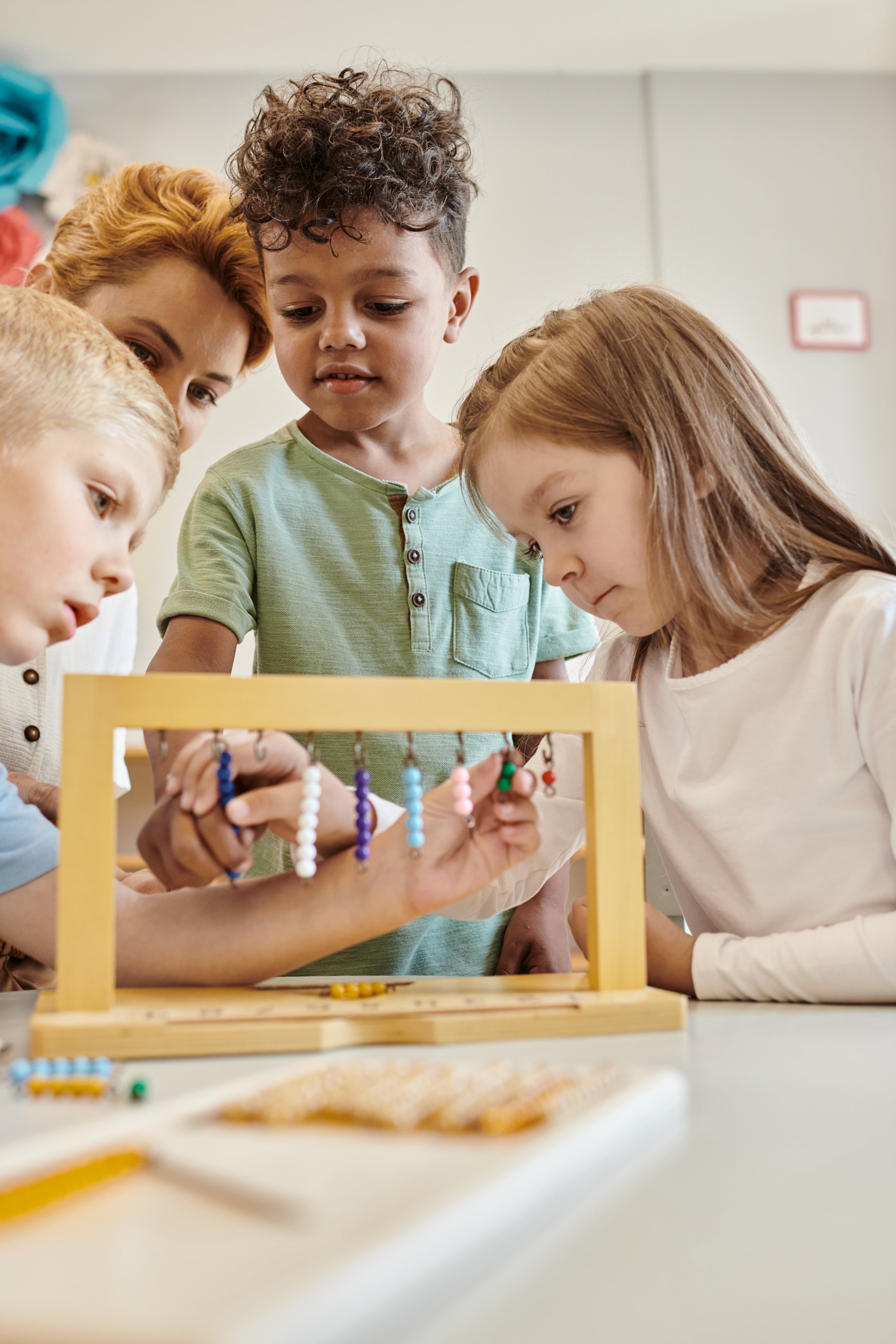 A teacher inspires children through playful learning using colorful Montessori materials in a vibrant classroom.
