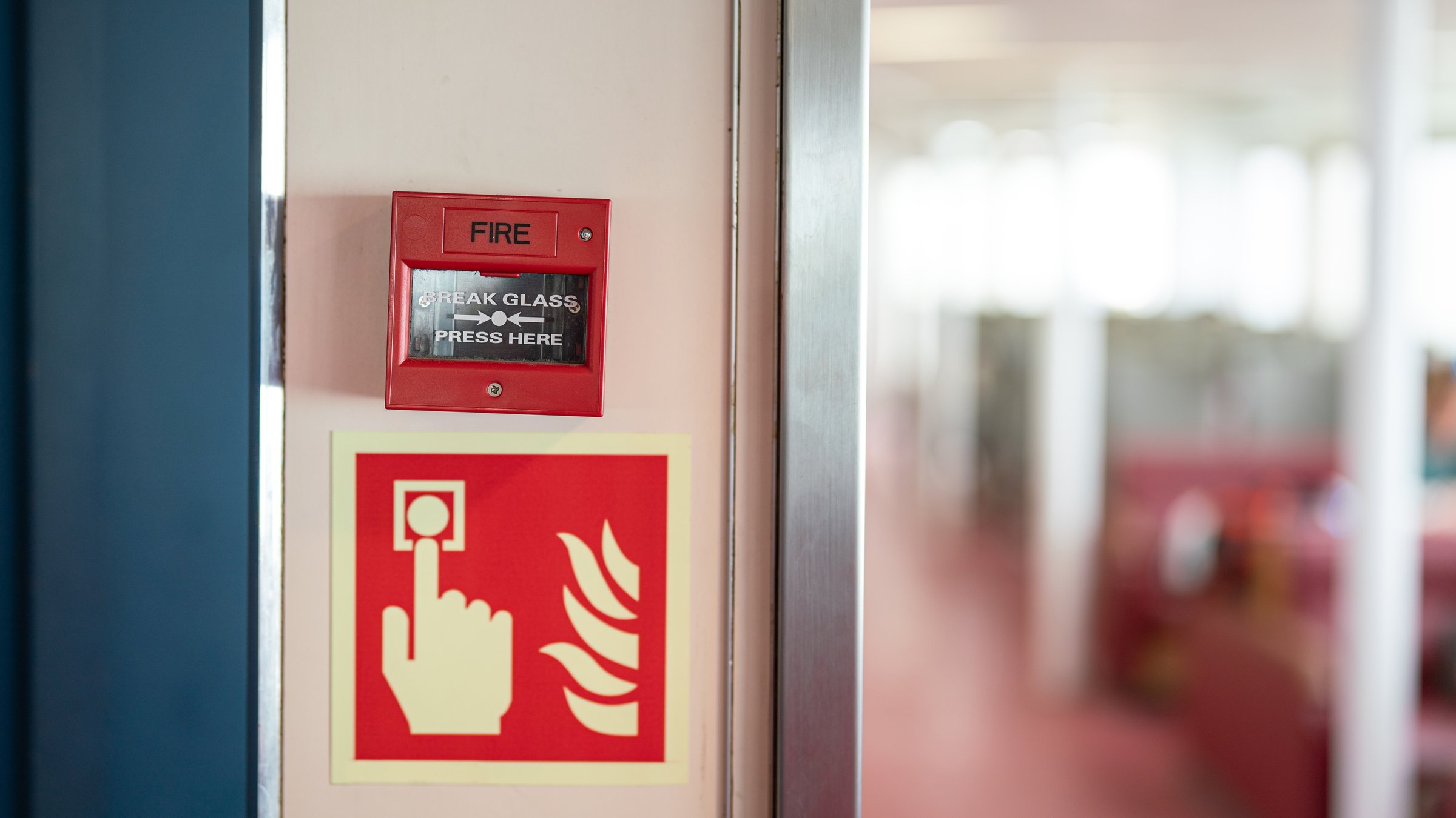 Fire alarm device that installed on building wall, press the button to activate sound in emergency fire case. Safety equipment object photo, close-up.
