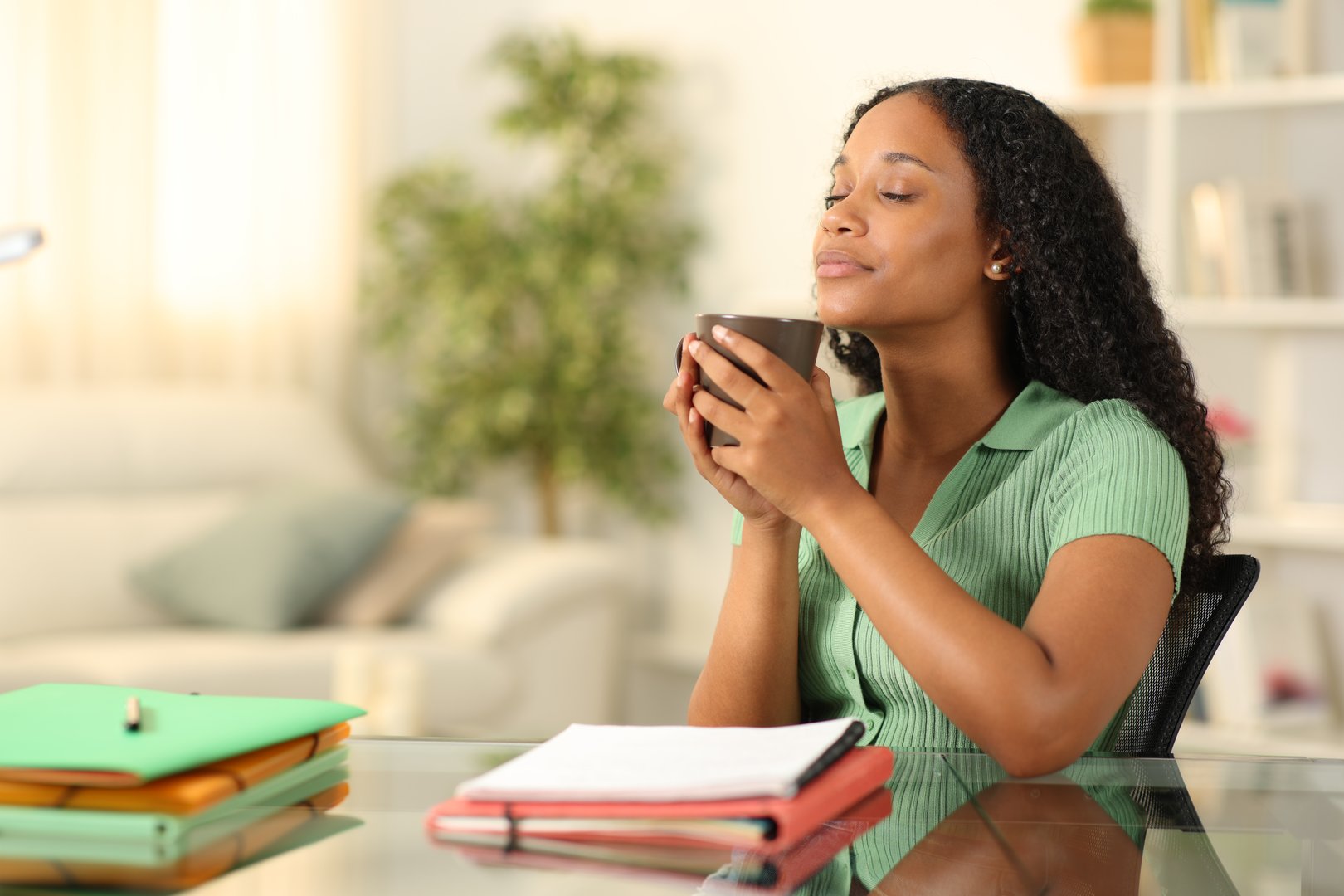Black student relaxing drinking coffee at home