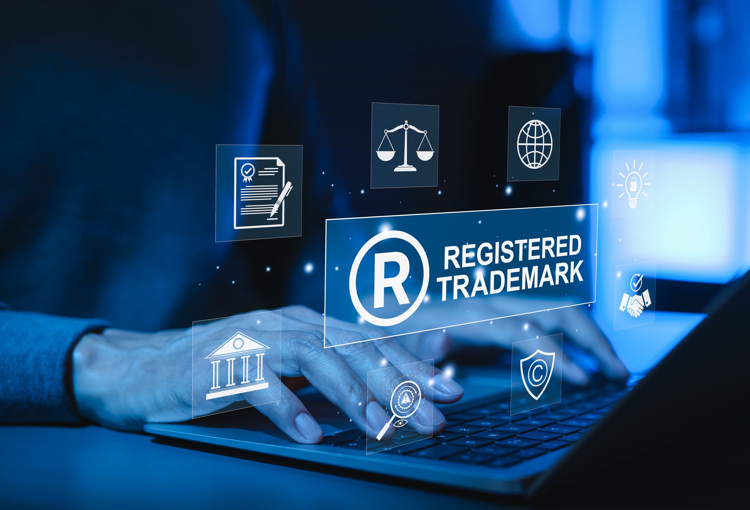 Registered trademark protection and intellectual property concept. Hands typing on laptop with icons registered trademark, legal protection, intellectual property rights, global business regulation,