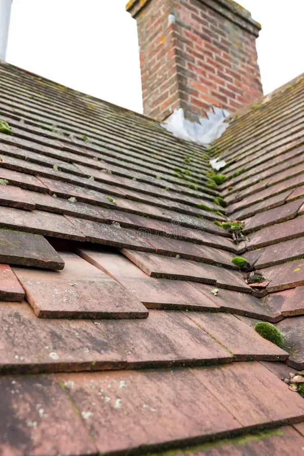 Missing slipped plain clay roof tiles on house roof UK