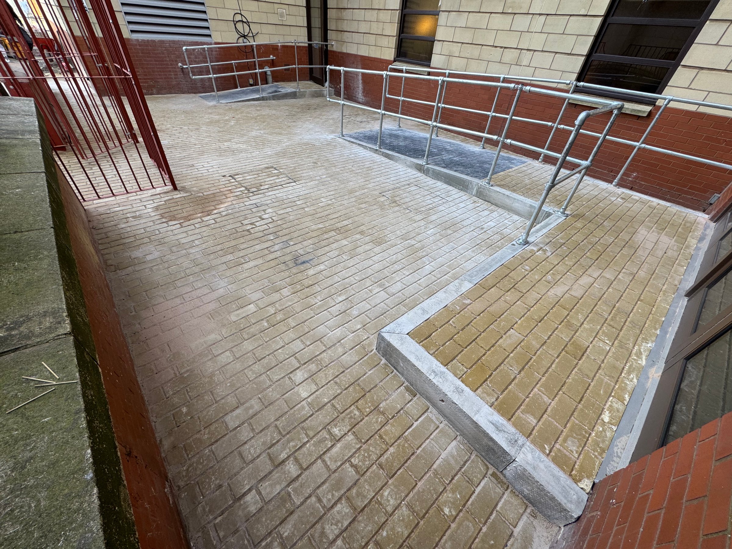Brick-paved access ramp with safety handrails by Taurus Facilities