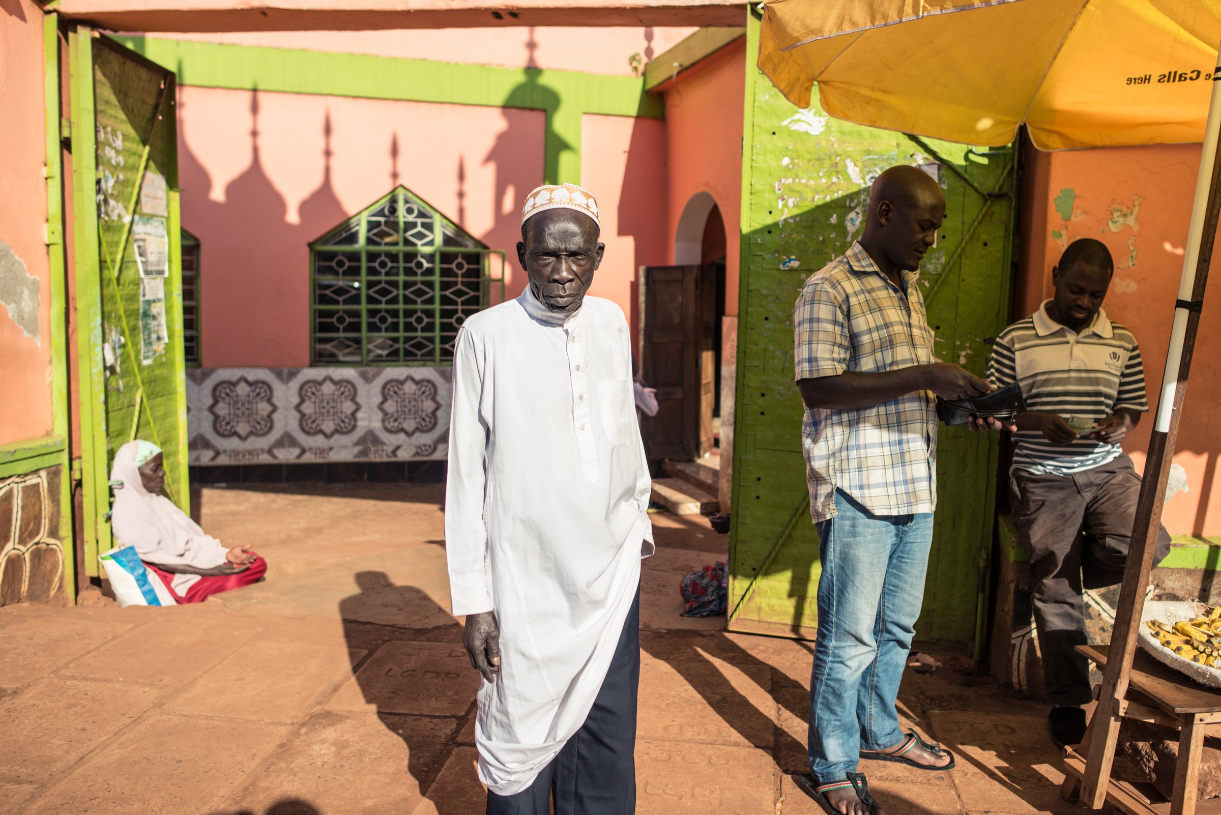 Jinja / Uganda - September 30, 2016: African Muslim man in front of mosque gate in Uganda with traditional clothes