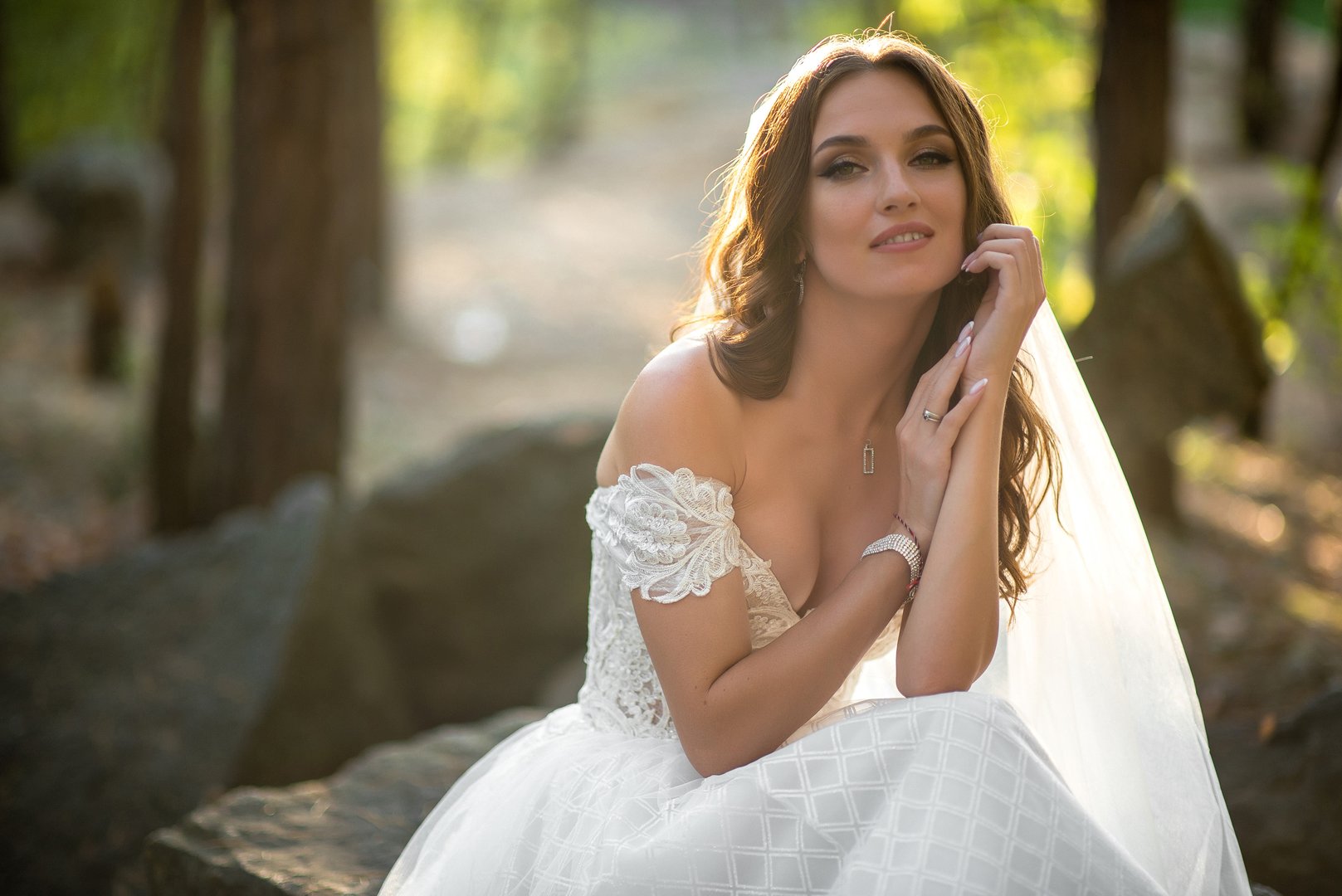 Portrait of a beautiful bride in a white wedding dress in the sunbeam
